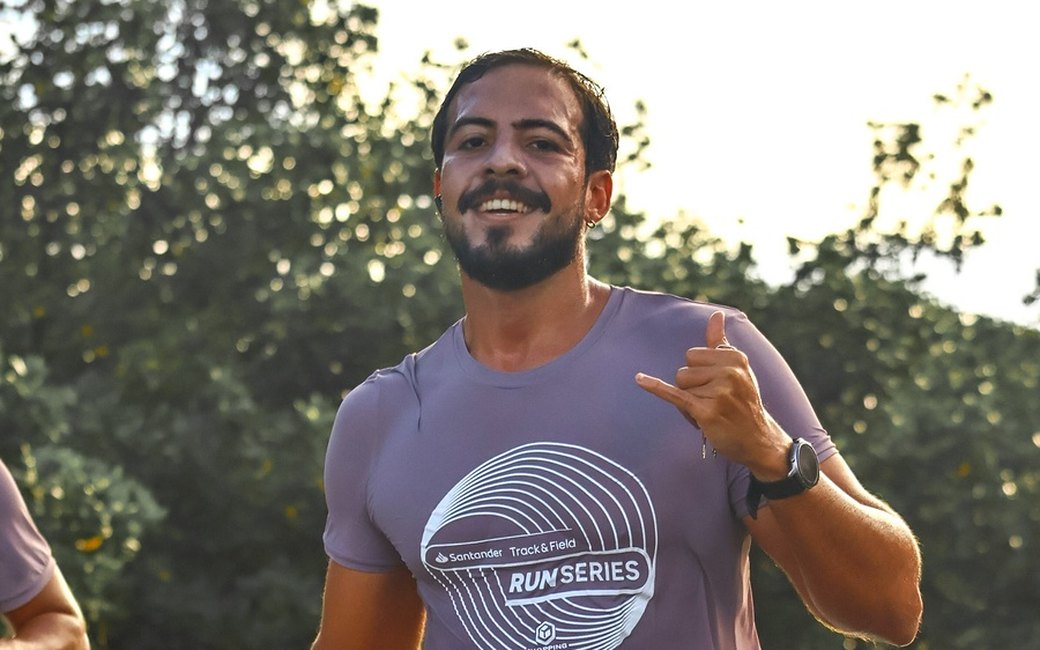 José Ricardo sorrindo e fazendo sinal de shaka durante uma corrida de rua